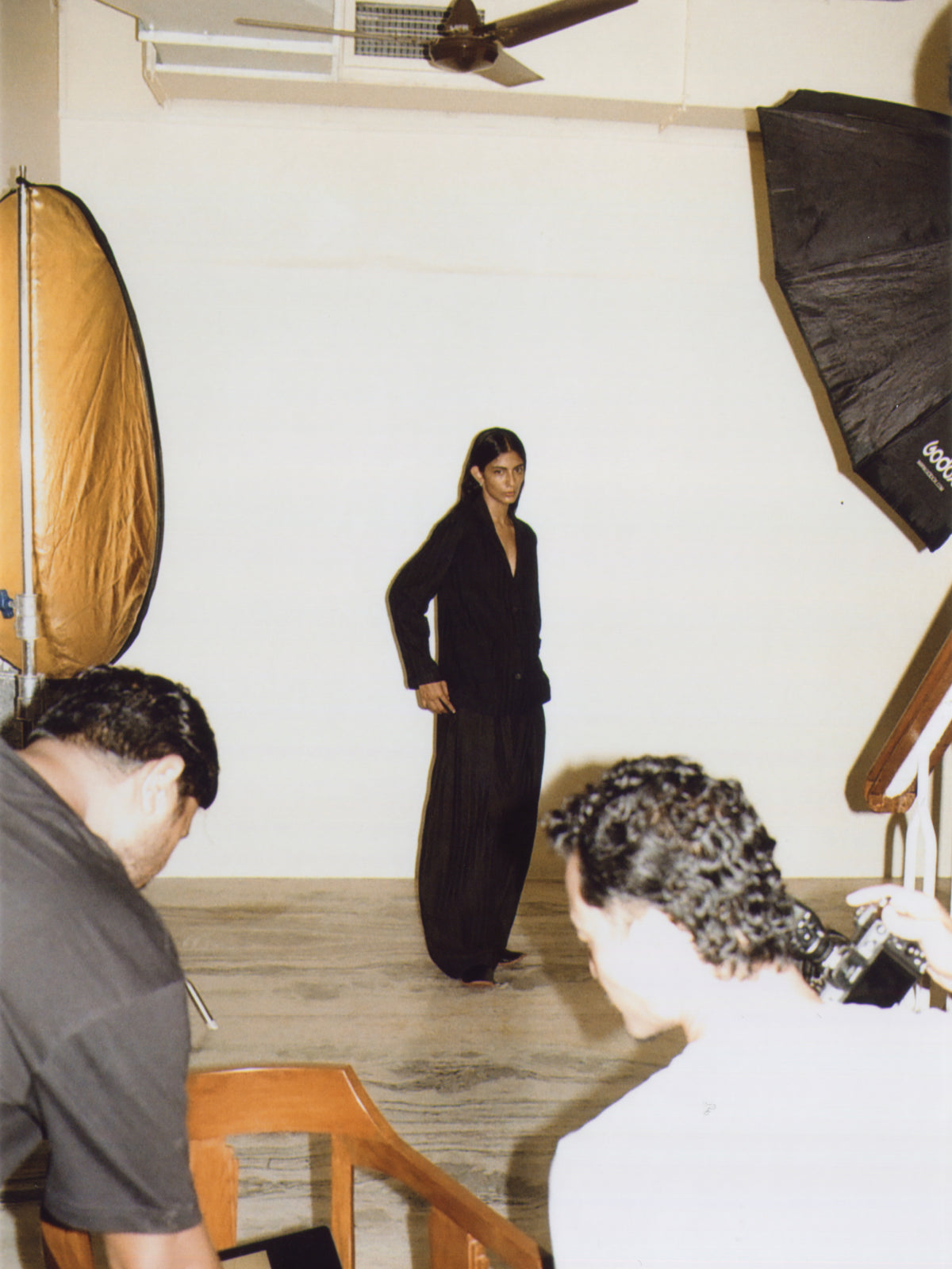 Modelo con traje negro de pie frente al estudio de Iro Iro